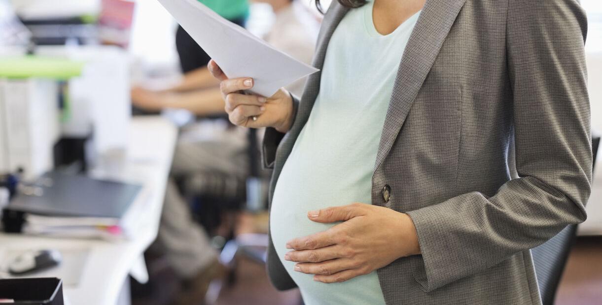 Pregnant businesswoman working in office Generic